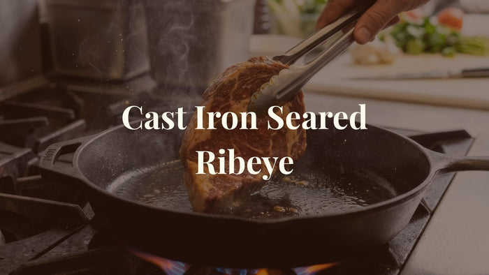 Grass-Finished Ribeye cooking on a cast iron pot with overlay text Cast Iron Seared Ribeye